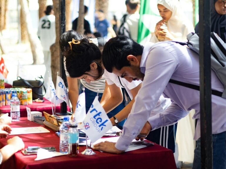 Students registering at a university stall at a career fair